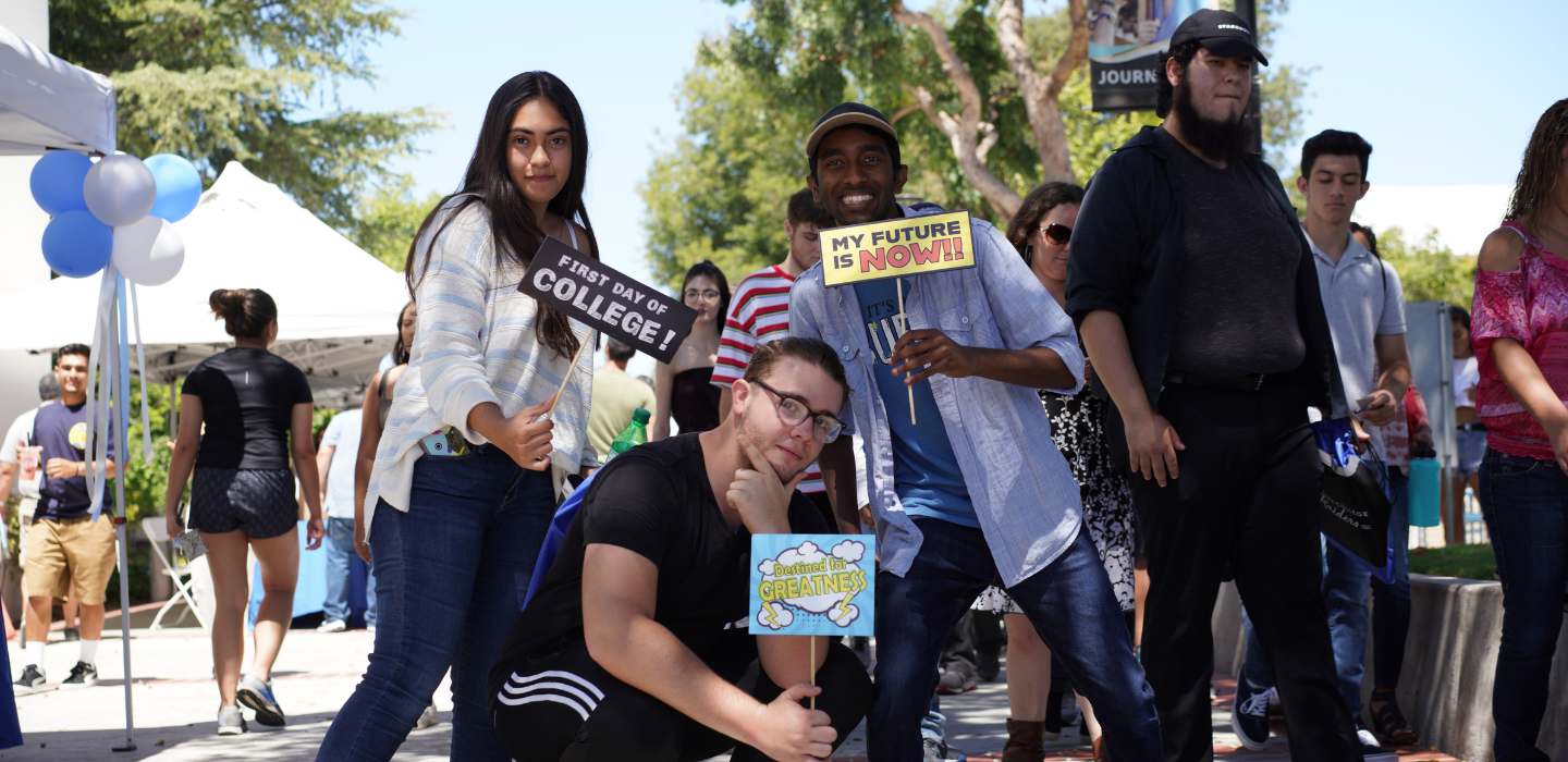 A group of students pose with some fun signs