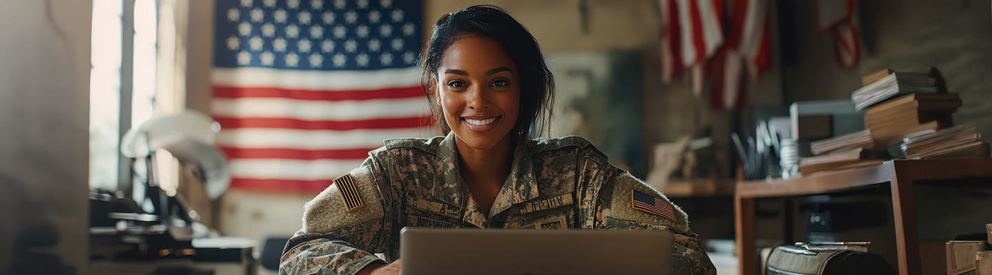 military person smiles at camera with flag in background
