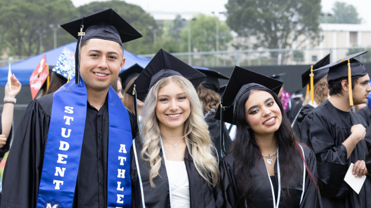 Graduates smile for a picture as they line up for the procession during Commencement
