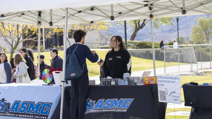 ASMC Director of Student Organizations&nbsp;Nora Barakat&nbsp;talks to a student during Club Rush 2024.